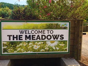 The Welcome to The Meadows sign on a planter at the entrance